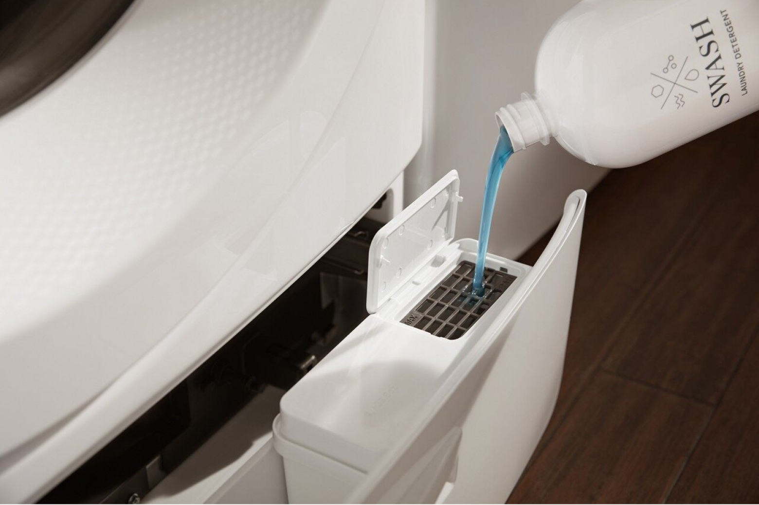 Laundry detergent pouring into washing machine dispenser
