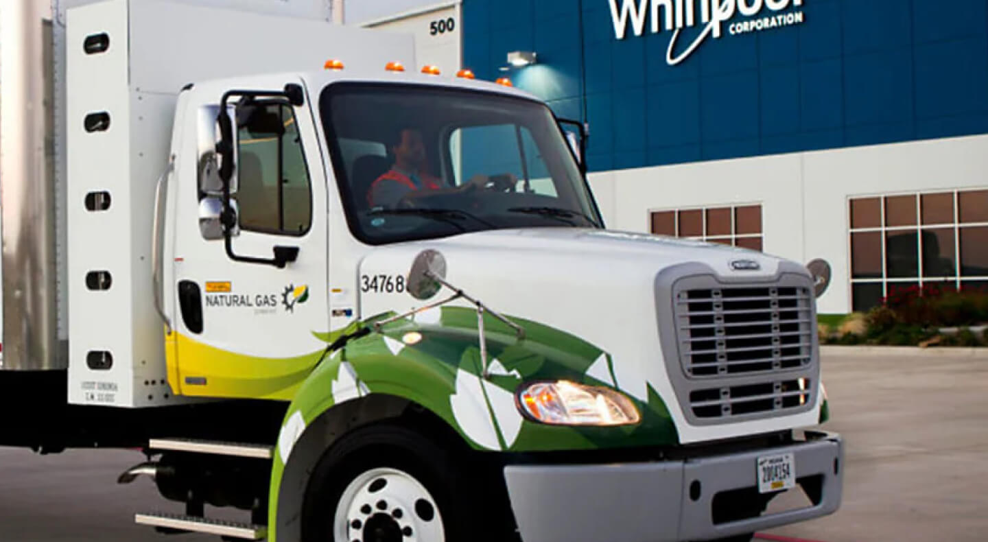 Front cab of semi truck in front of a Whirlpool Corporation building