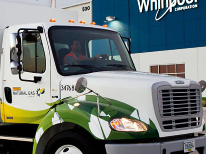 Front cab of semi truck in front of a Whirlpool Corporation building