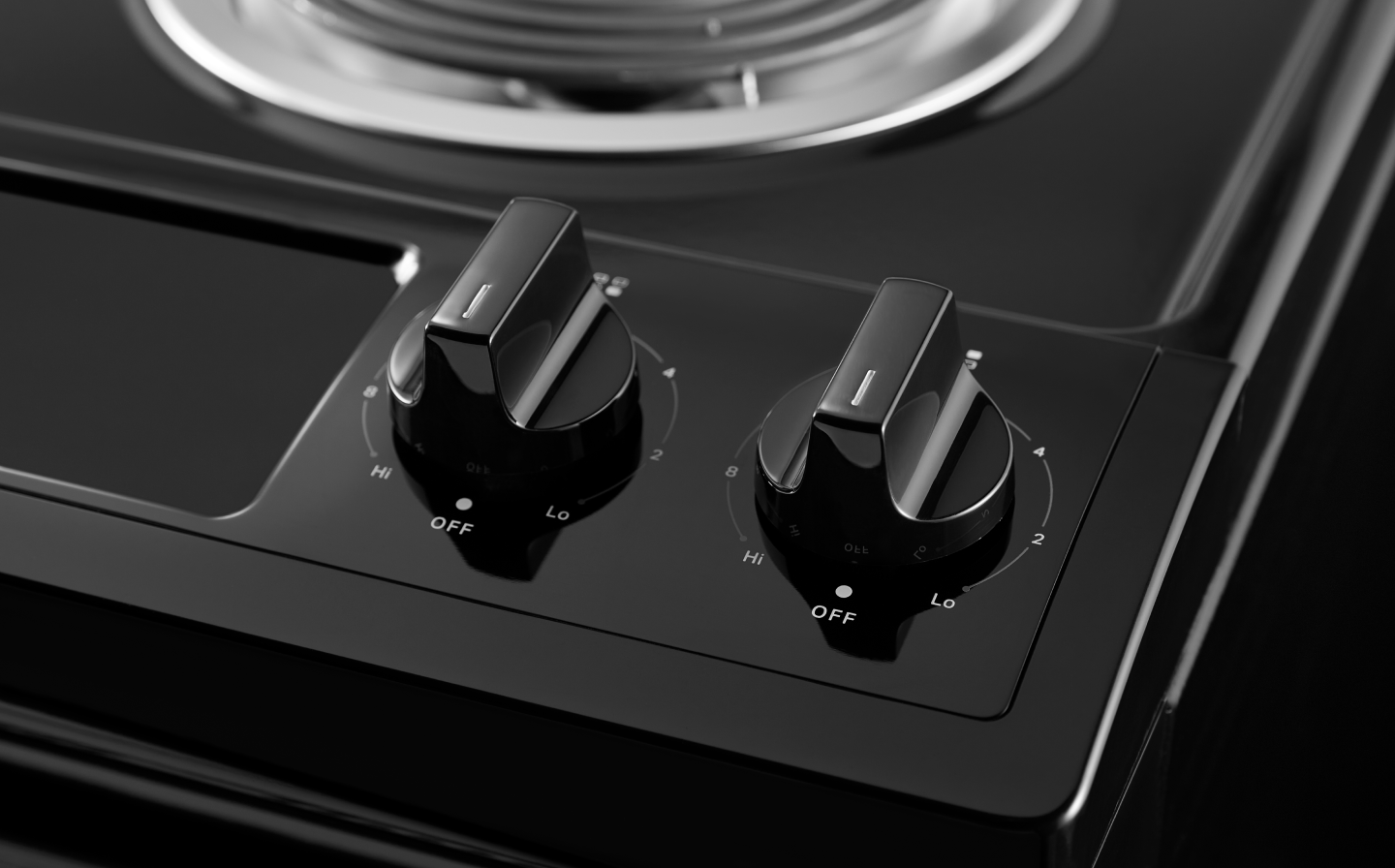 A closeup of the burner control knobs on a Whirlpool® electric range.