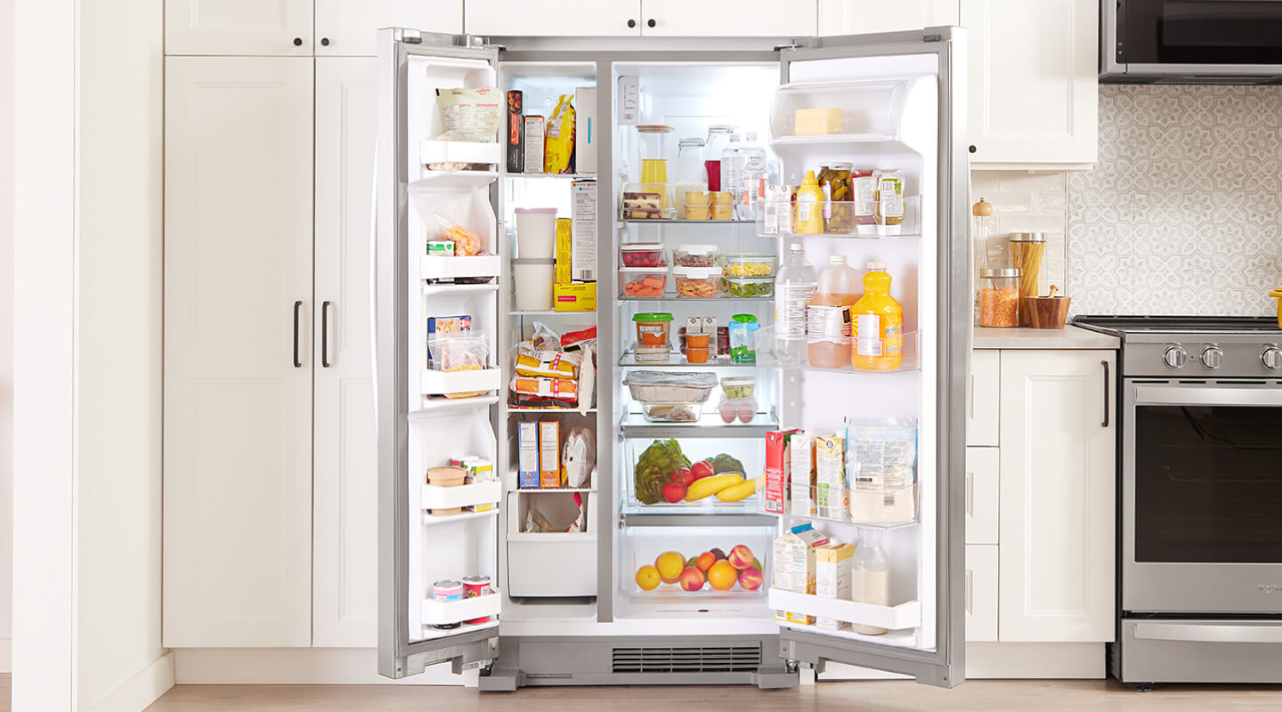 A side-by-side refrigerator with both doors opened to reveal a fully stocked interior
