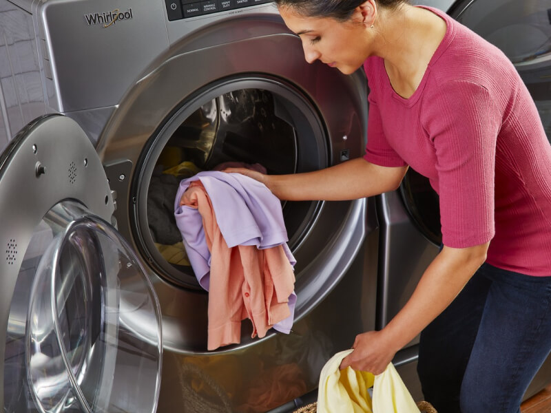 A person loading a washer