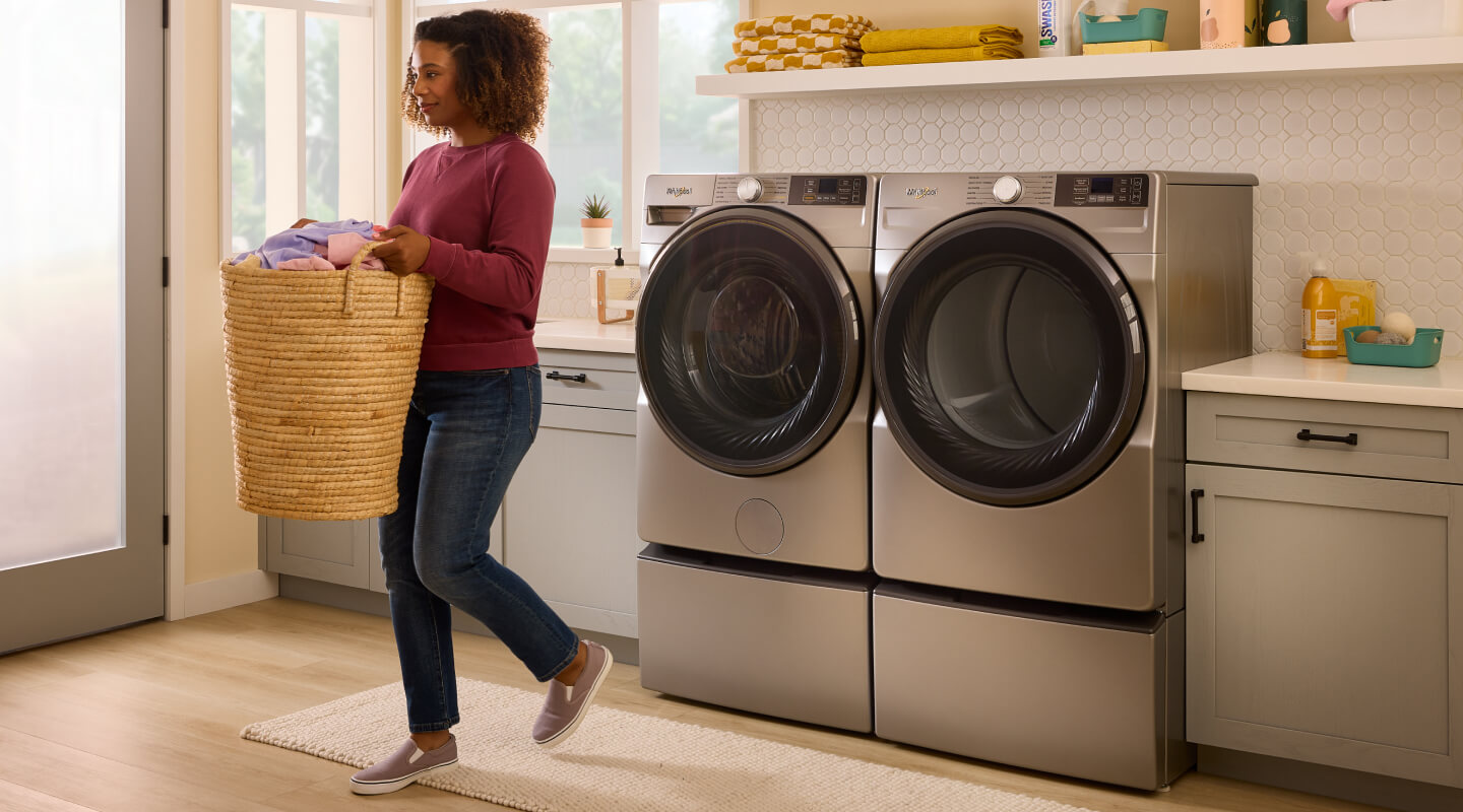 Person in a laundry room with a basket of clean clothes
