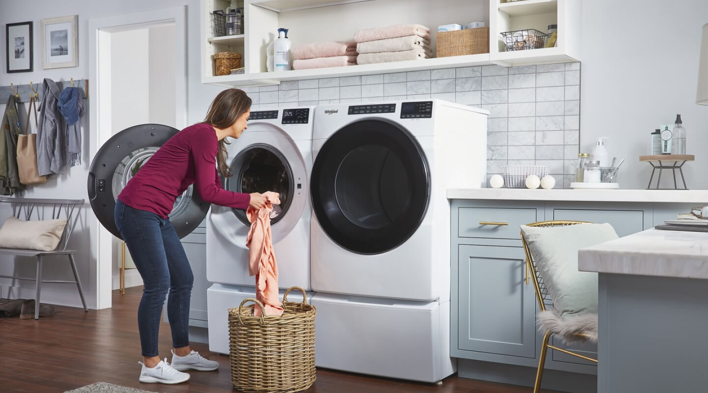 A woman loading clothes into a Whirlpool® Washer