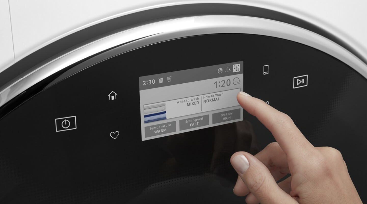 A person operating the control pad on their washing machine