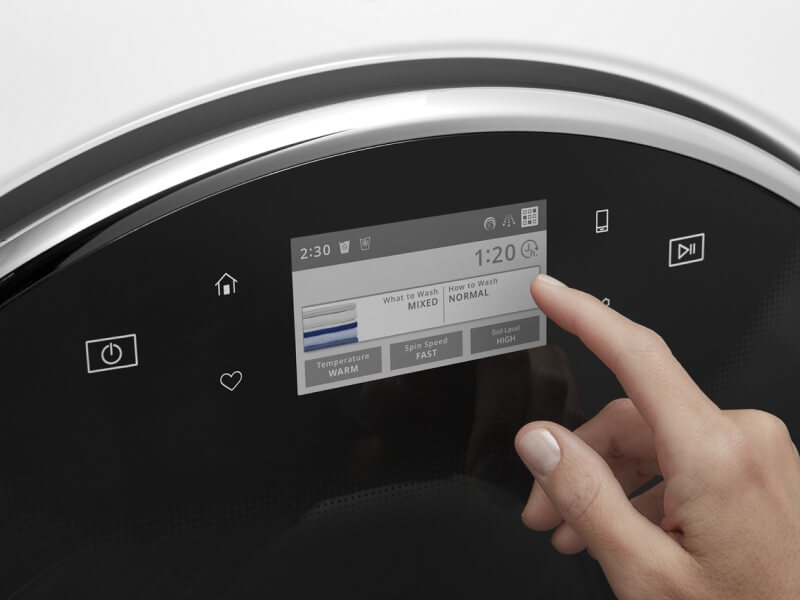A person operating the control pad on their washing machine