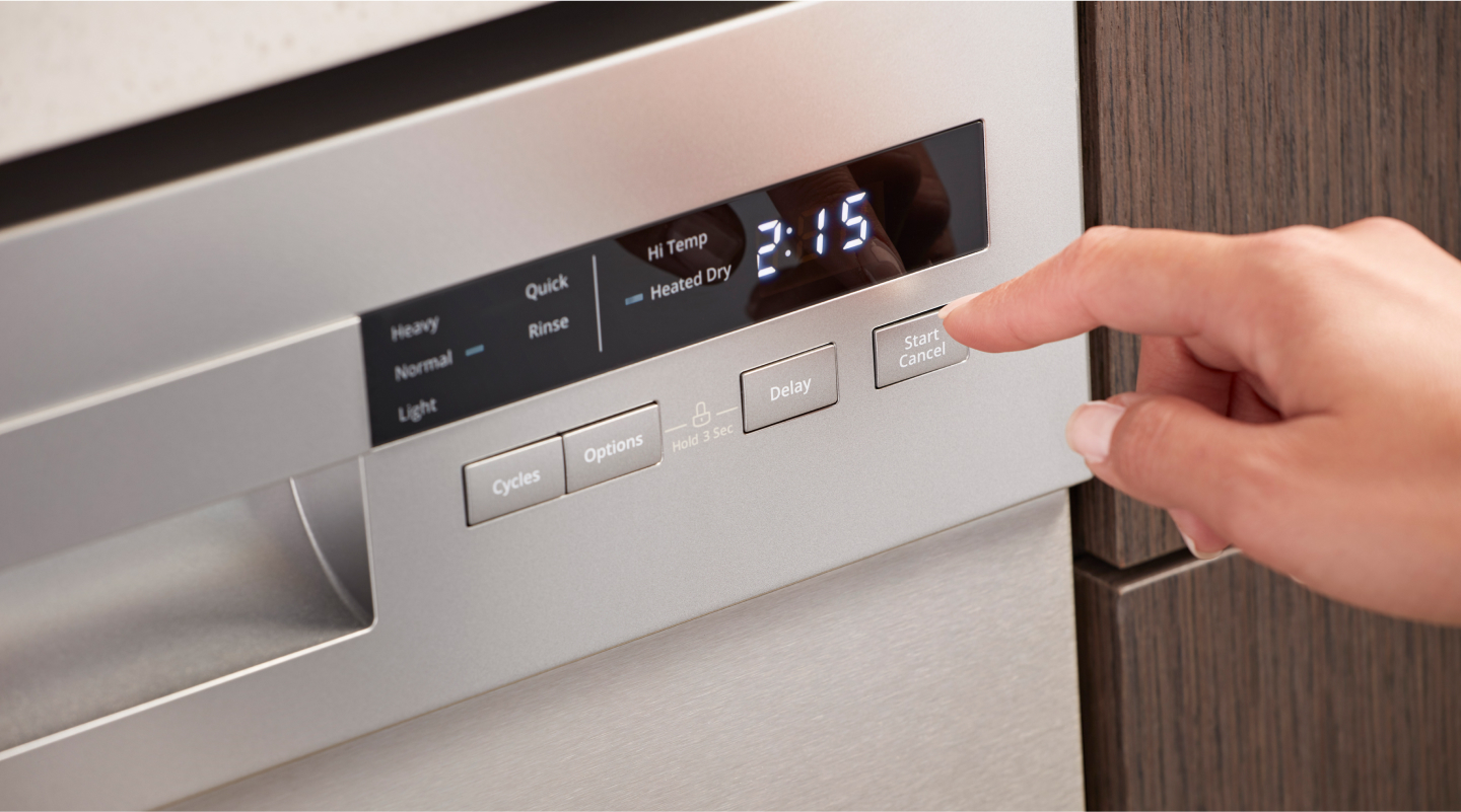 Person selecting wash cycle options on dishwasher control panel