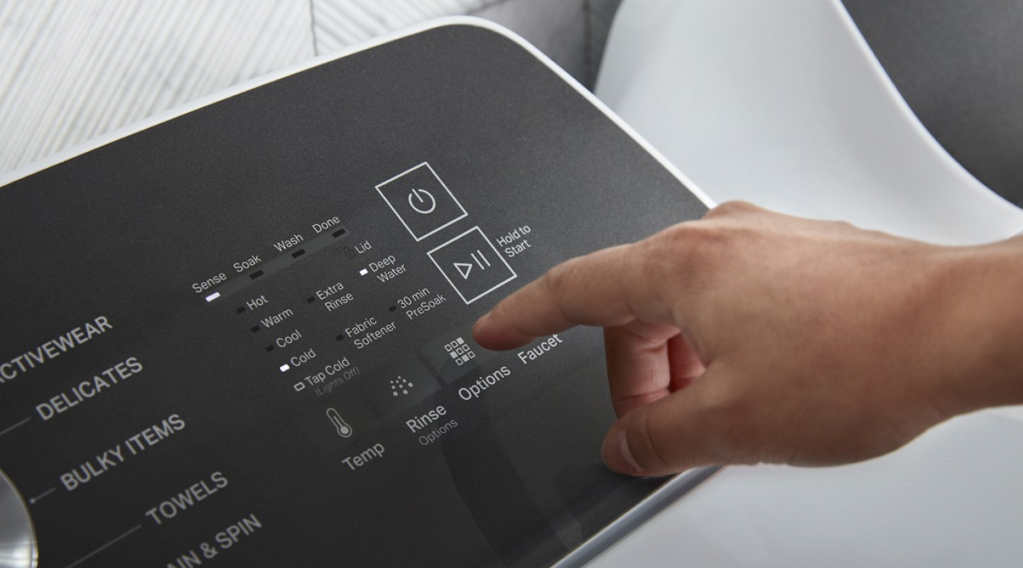 Person selecting settings on a washer control panel