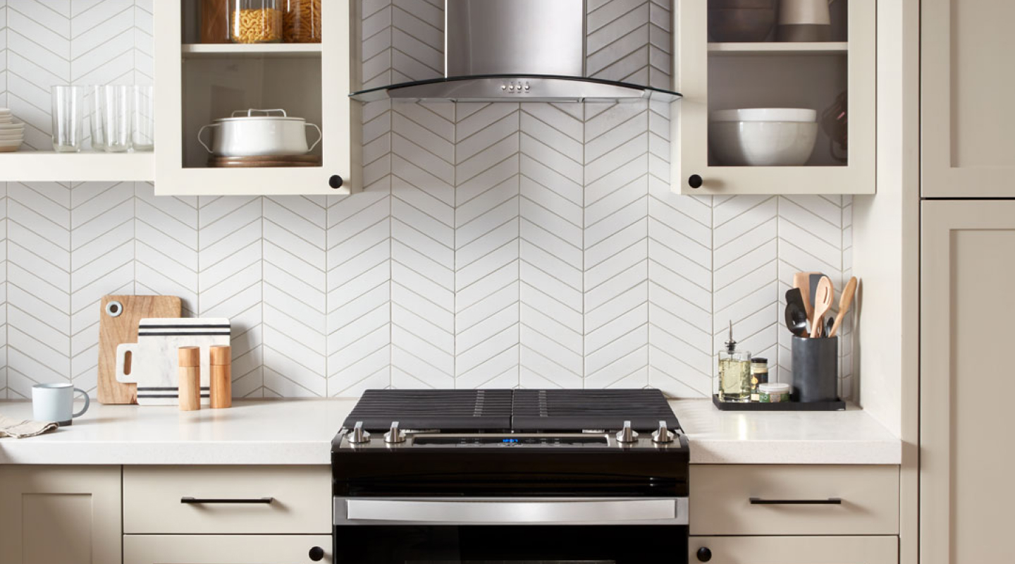 A black range and range hood in a modern kitchen