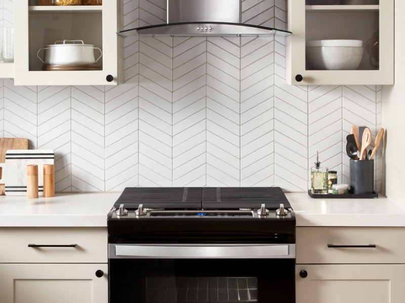A black range and range hood in a modern kitchen