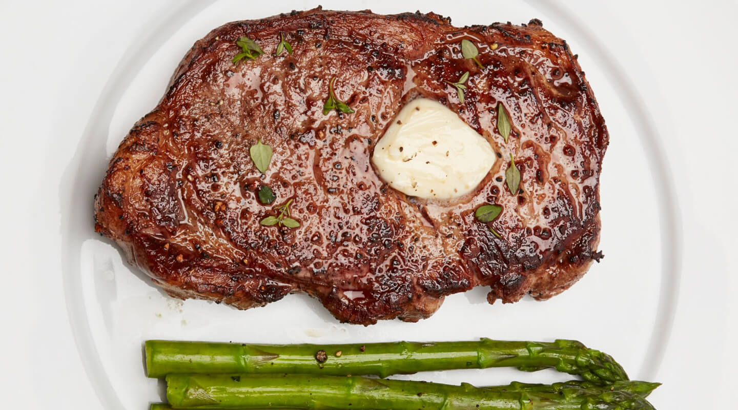 A seared steak with butter and roasted asparagus 