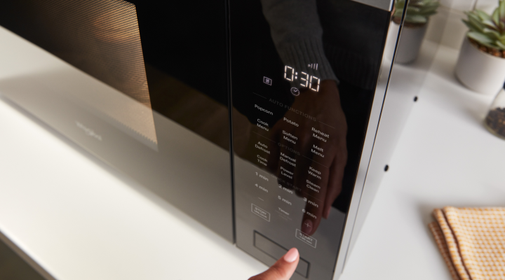 Person operating the control panel of a microwave