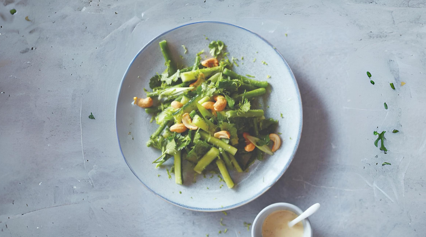 Cooked plate of green beans garnished in walnuts and cilantro