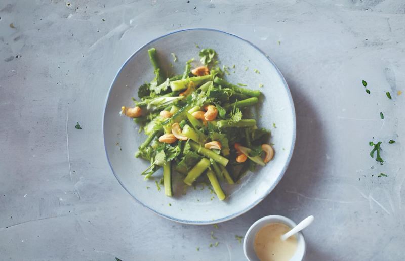 Cooked plate of green beans garnished in walnuts and cilantro