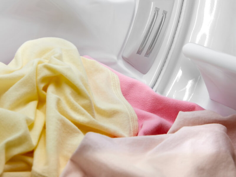 Yellow and pink garments in a dryer