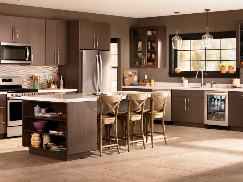 A kitchen with brown cabinets and stainless steel Whirlpool® appliances