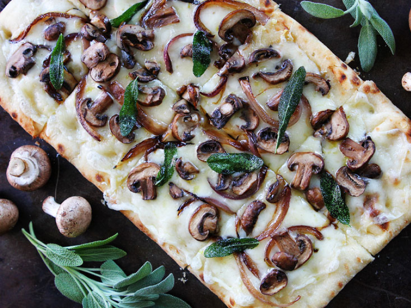 Flatbread pizza topped with cheese, mushrooms and herbs