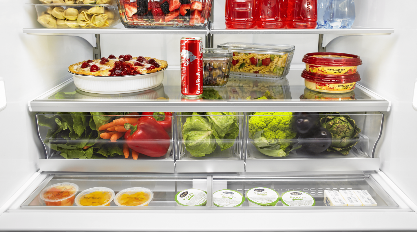 Open refrigerator full of produce, baked goods and beverages