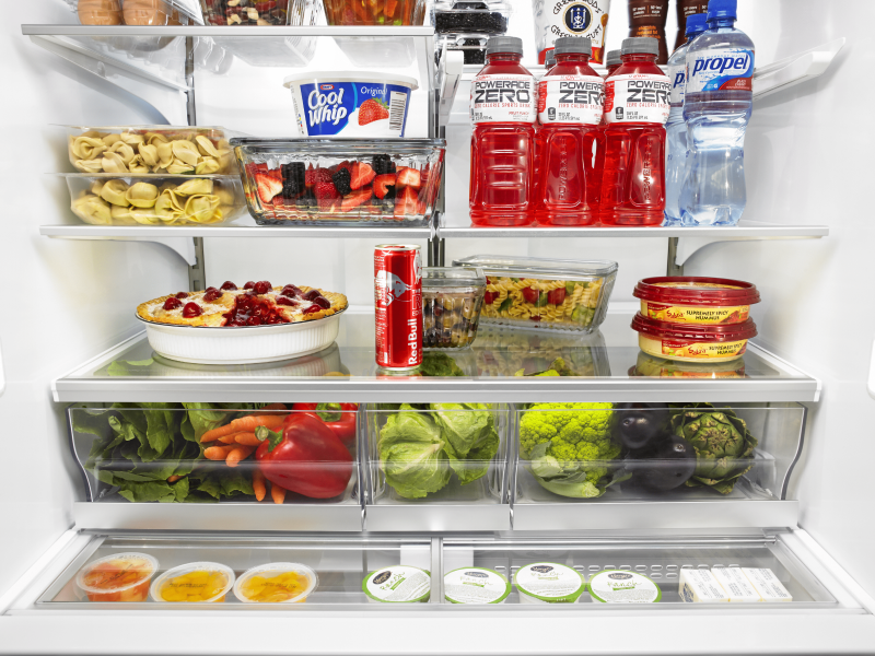 Open refrigerator full of produce, baked goods and beverages