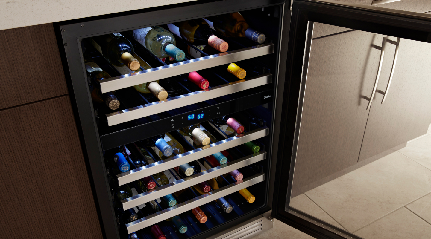 Wine bottles stored on the various levels of a wine fridge