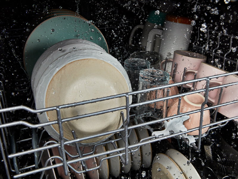 A closeup of dishes being cleaned in a dishwasher