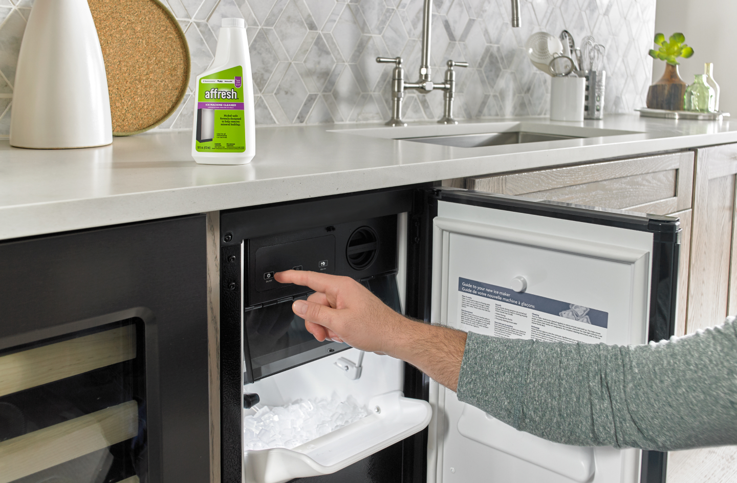 Person opening a built-in icemaker next to affresh® cleaner
