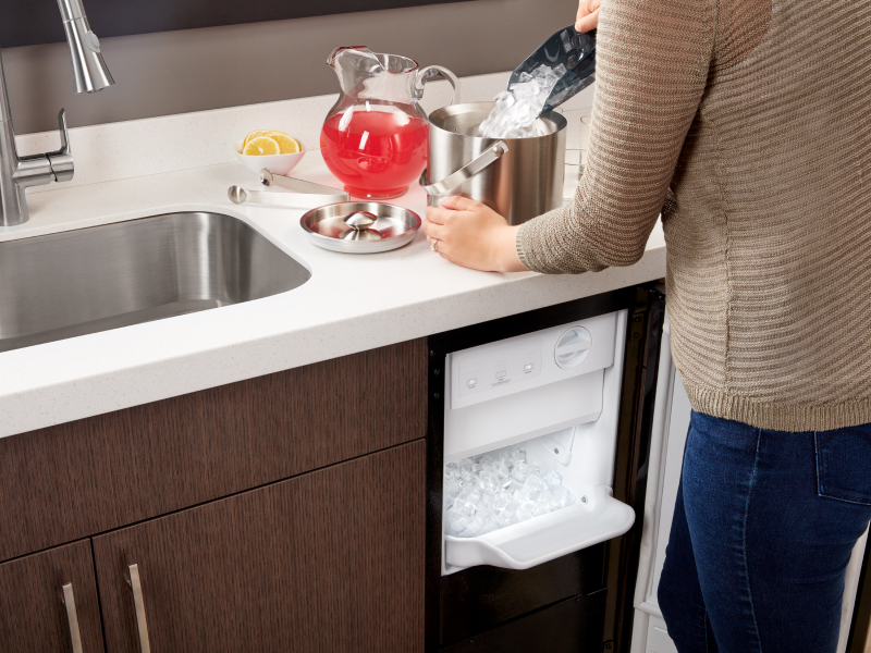 Person filling an ice bucket from a Whirlpool® icemaker
