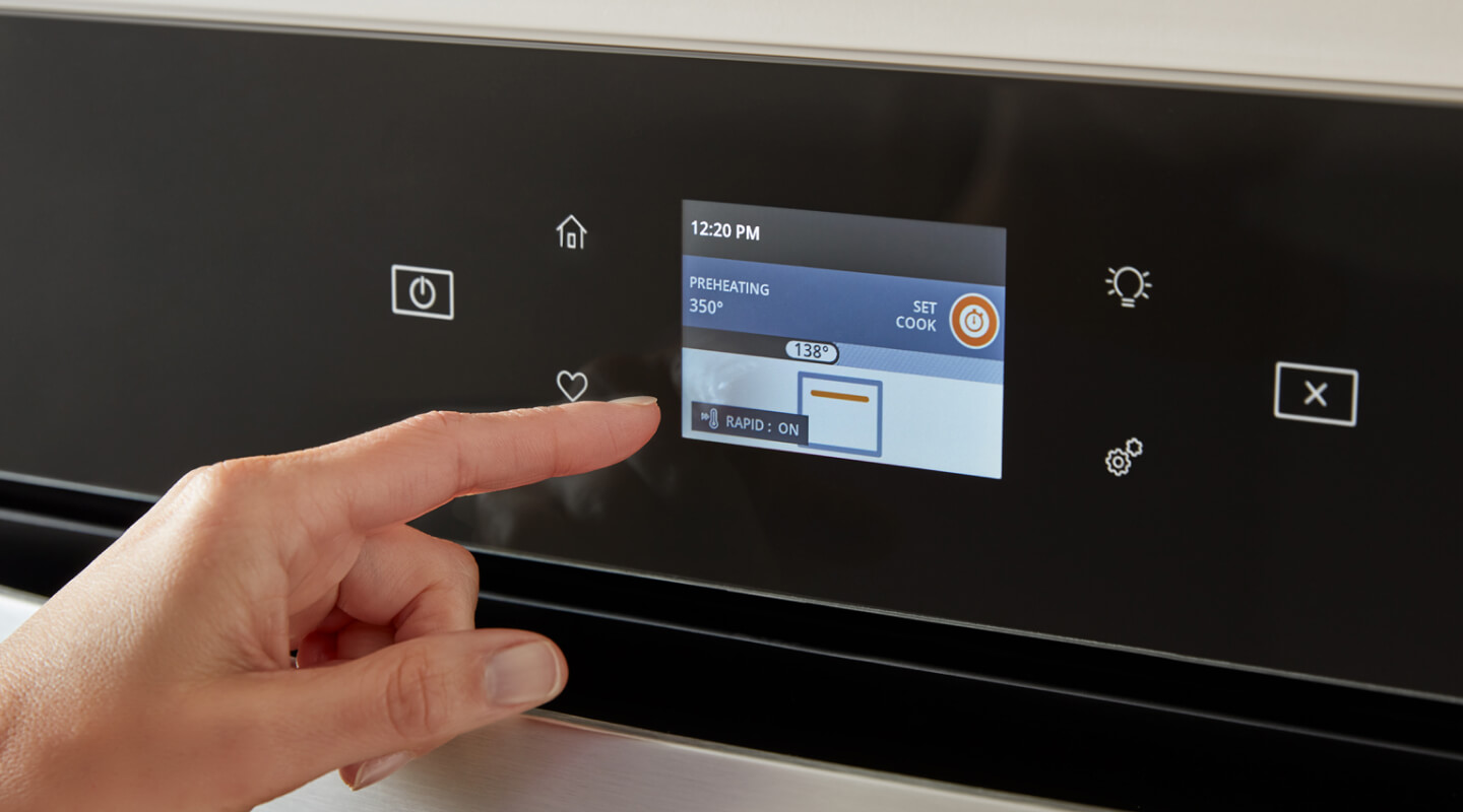 A person selecting a setting on an oven control panel