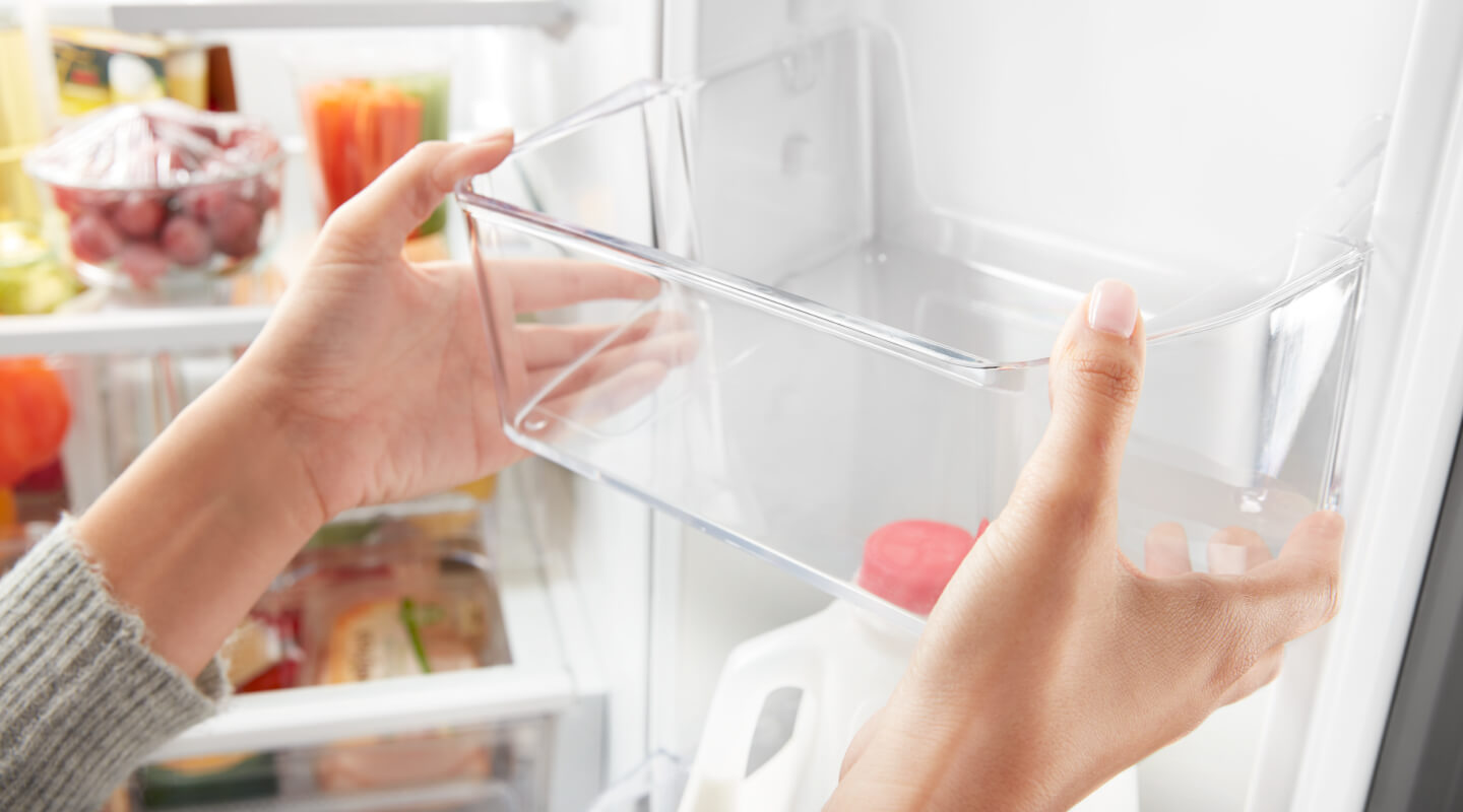 Person adjusting a shelf on the inside door of a refrigerator