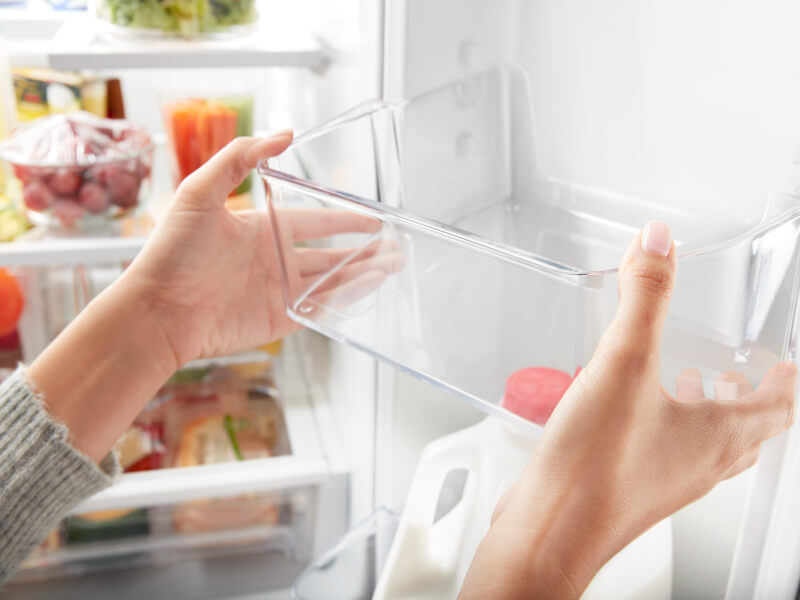 Person adjusting a shelf on the inside door of a refrigerator