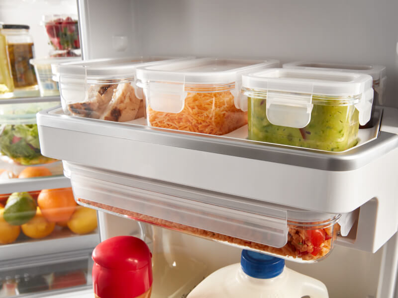 Food items in containers on a refrigerator shelf
