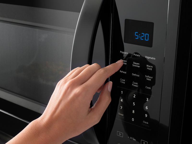 Hand pressing a microwave display