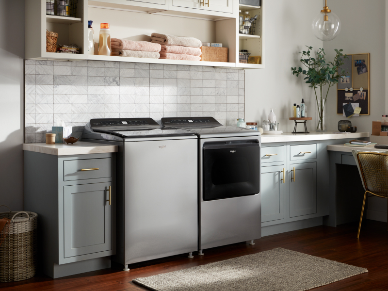 Whirlpool® top load washing machine and dryer in a rustic laundry room