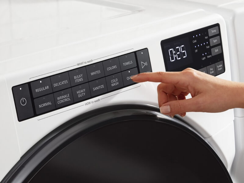 Person selecting settings on a washer control panel