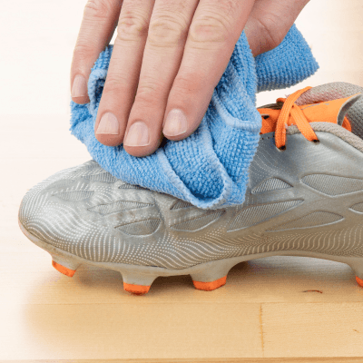 Person wiping a cleat with a microfiber cloth