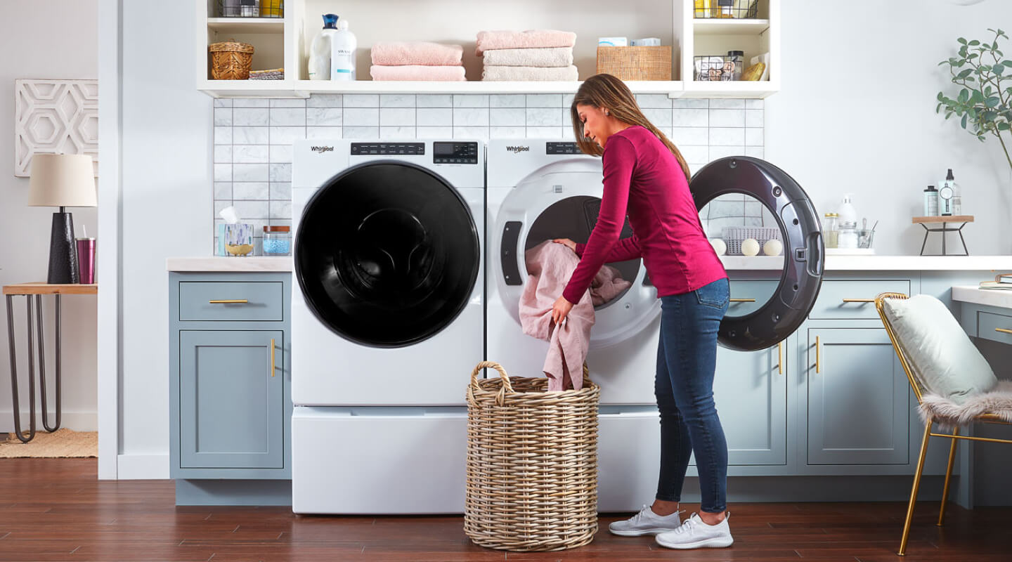 Person loading laundry in a front load dryer