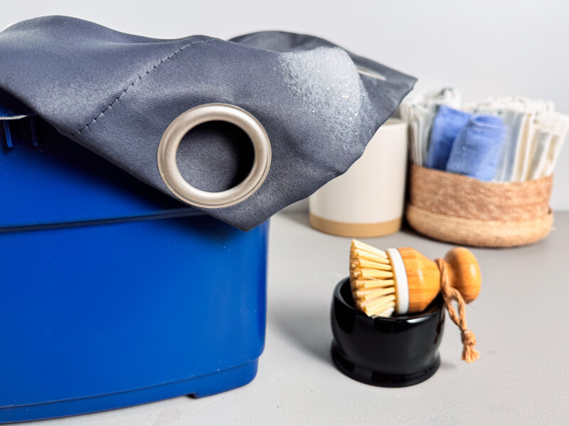 Grey curtains in a blue bucket