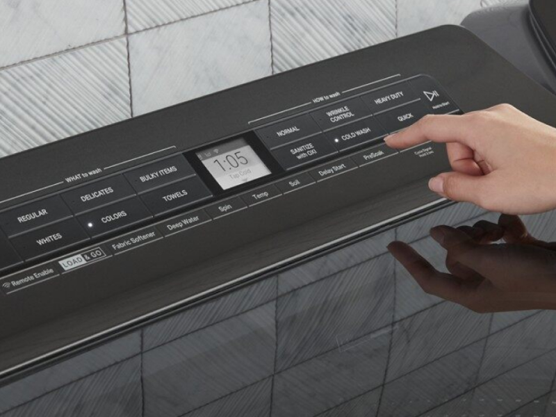A woman programming the settings of a Whirlpool® dryer panel