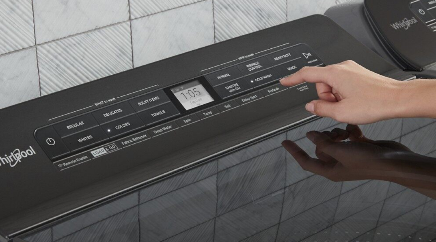 A woman programming the settings of a Whirlpool® dryer panel