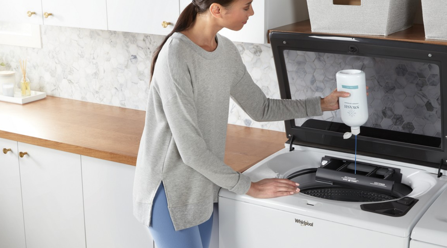 Person adding Swash® to a washing machine