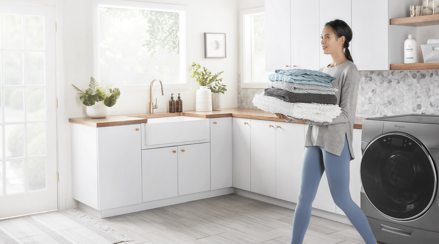Person carrying towels in a laundry room