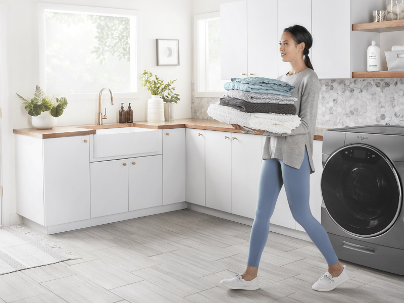 Person carrying towels in a laundry room