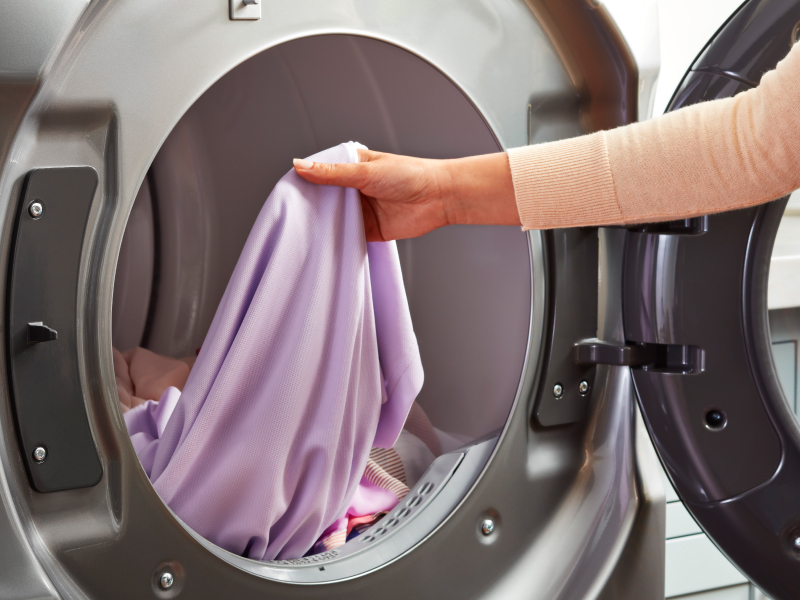 Person removing garment from the dryer