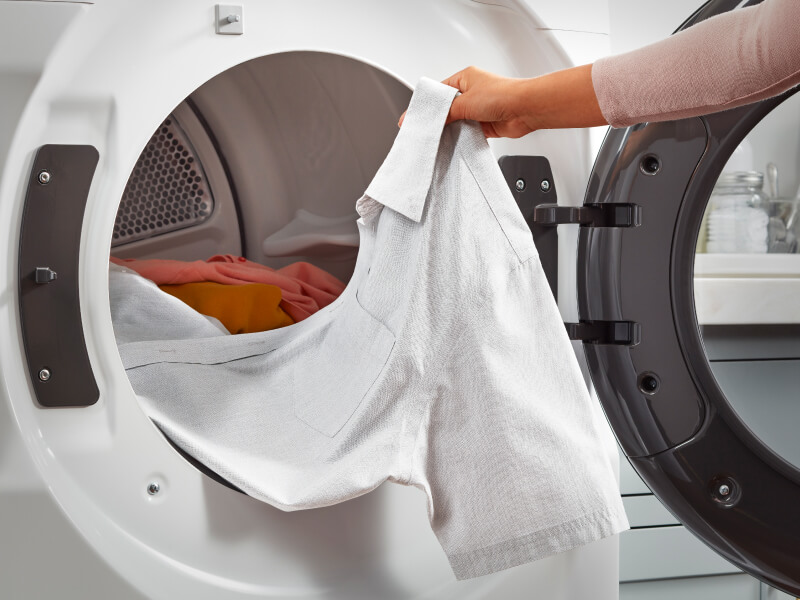 Person pulling a shirt out of a dryer