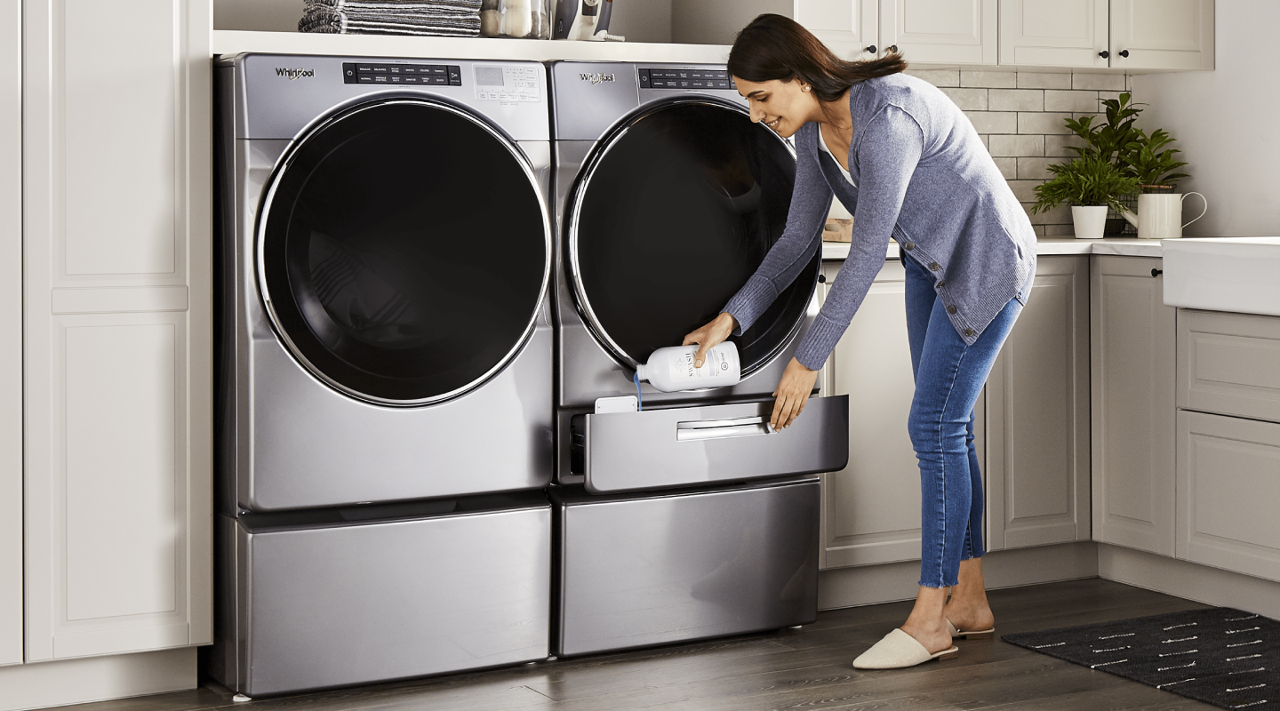 A woman pouring Swash® laundry detergent into a Whirlpool brand washing machine