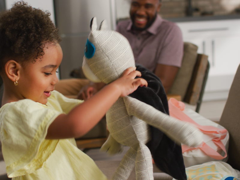 A young girl playing with a stuffed panda