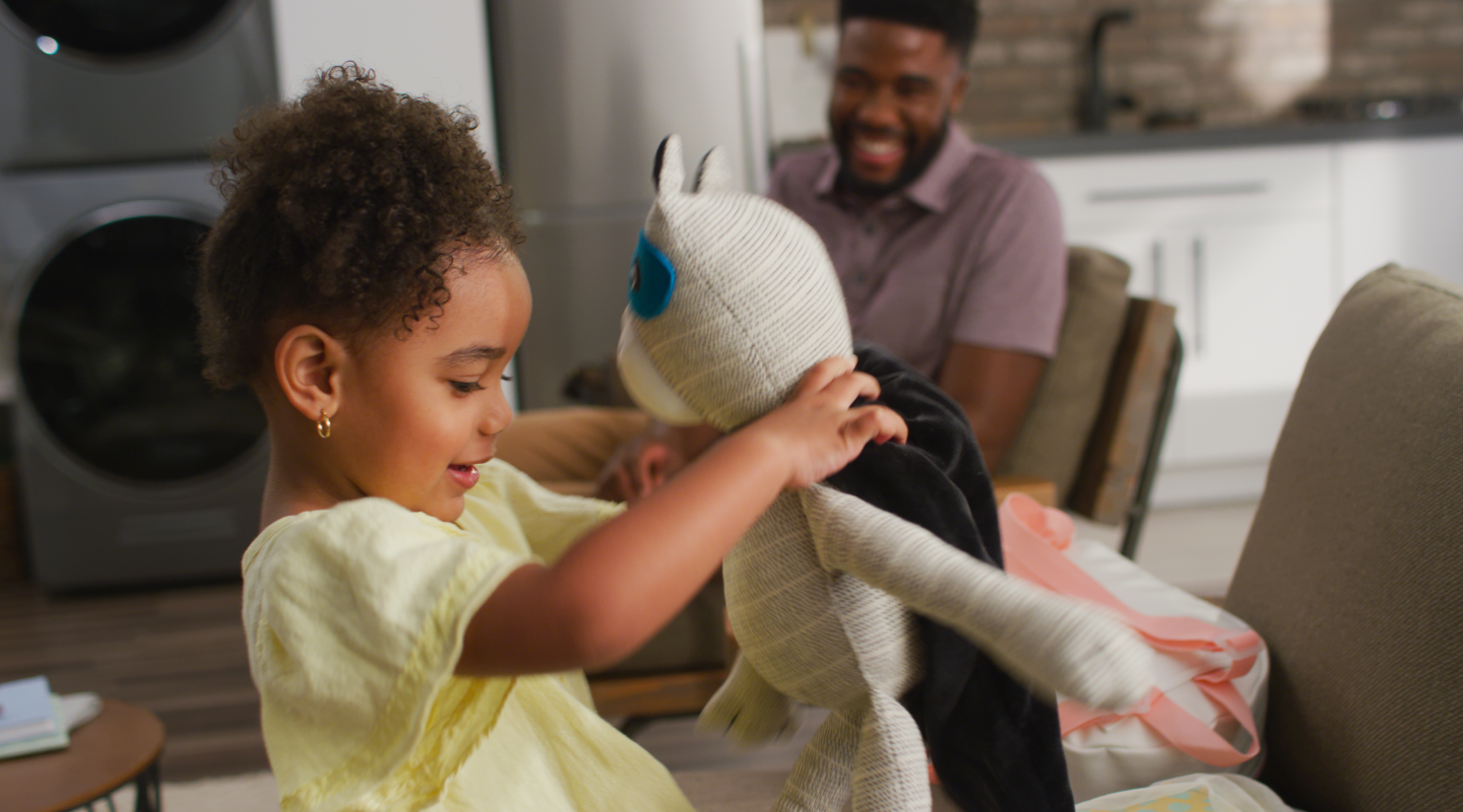 A young girl playing with a stuffed panda