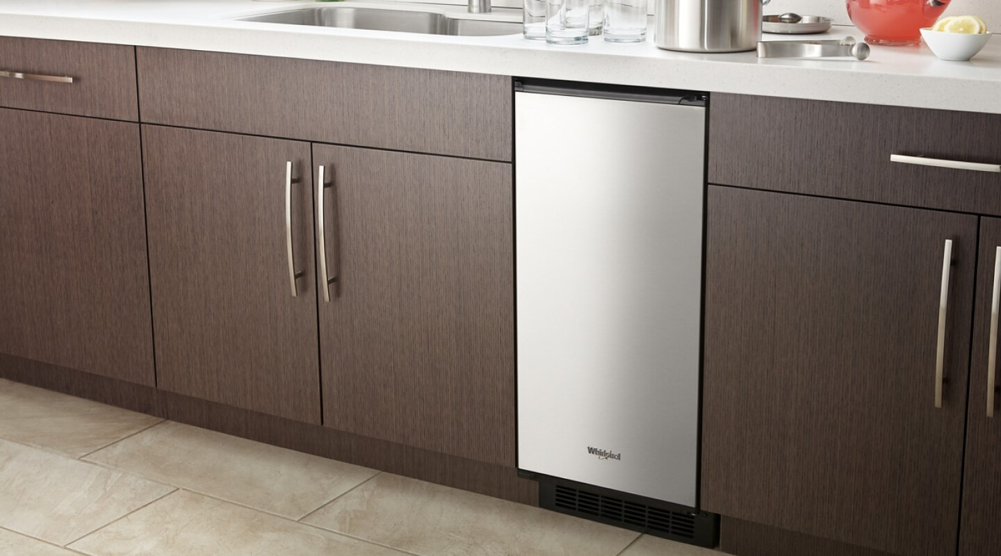 Stainless steel Whirlpool® Built-in Icemaker set in wood cabinetry