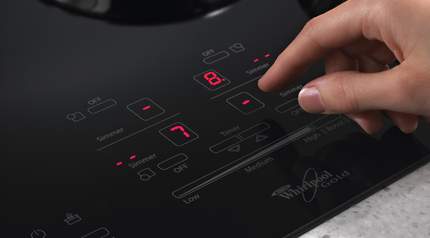 Person adjusting settings on an induction cooktop