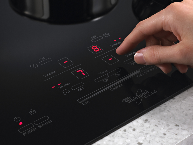 Person adjusting settings on an induction cooktop